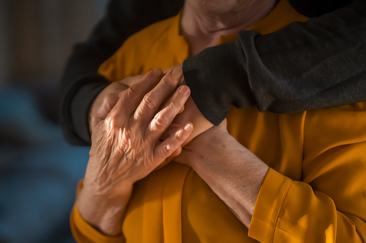 Man support his old grandmother, holds her hands.